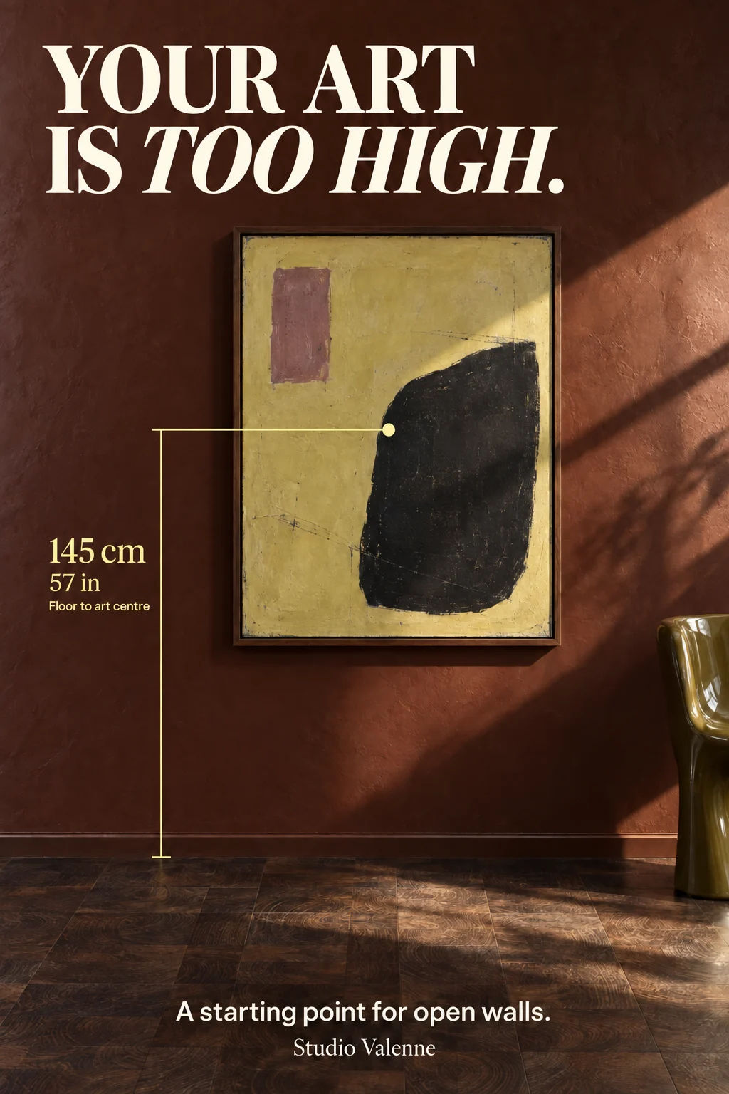 A framed citron, black and mauve abstract artwork hangs on an oxblood wall in diagonal sunlight. Ivory lettering reads Your art is too high. A yellow measurement line shows 145 cm / 57 in from the floor to the artwork’s center, with the note A starting point for open walls.