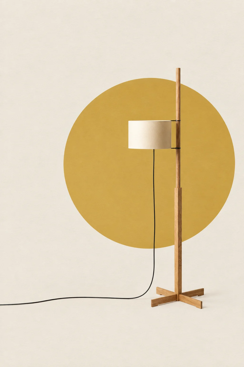 Miguel Milá’s TMM floor lamp, with a wooden stem, cross base and pale cylindrical shade.